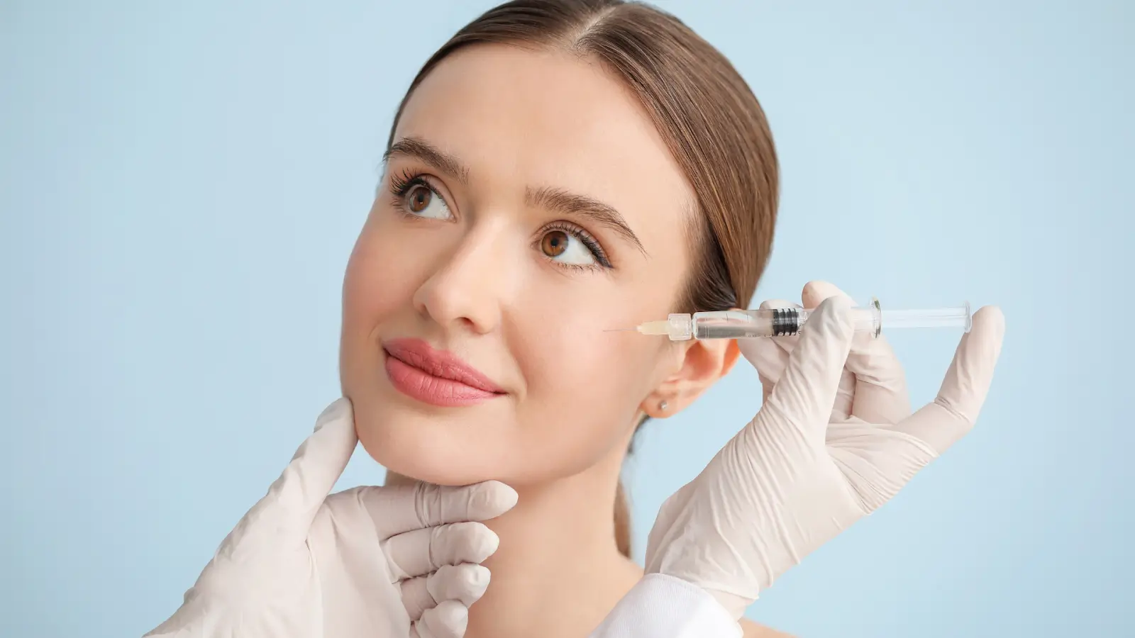 A female patient receives dermal filler treatment.