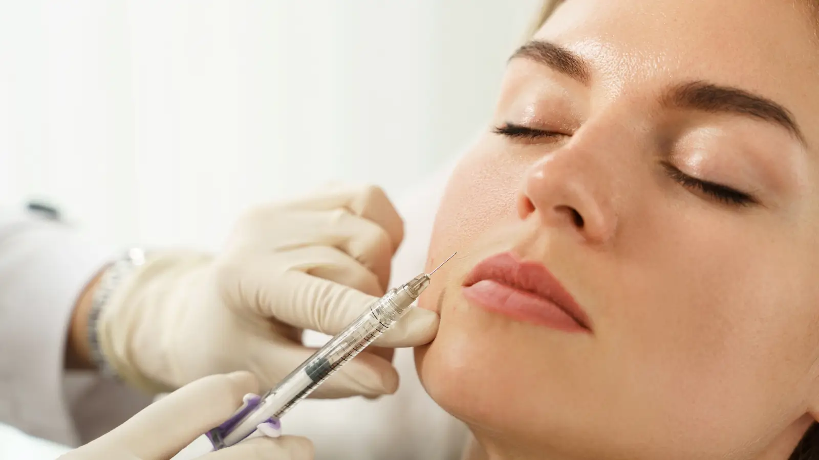 A female patient receives filler treatment for facial rejuvenation.